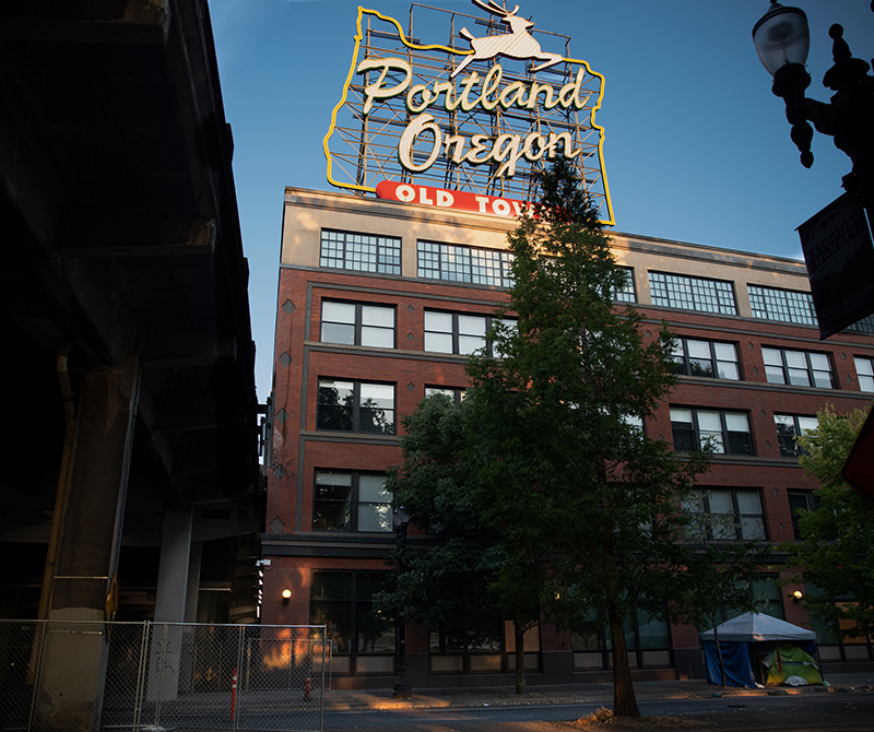 A photo looking up at the White Stag building in Portland. It shows the neon Portland sign from the street level.