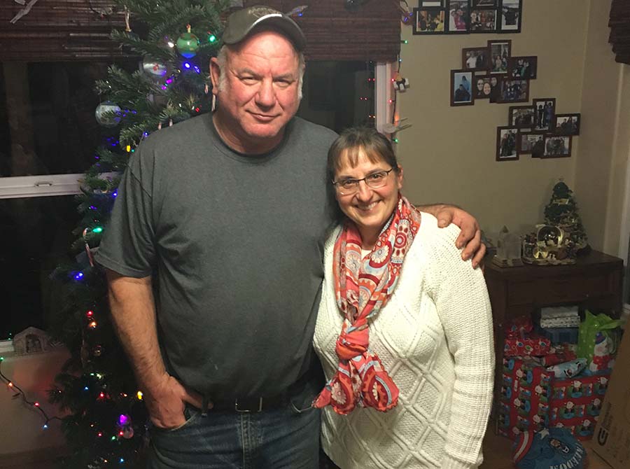 Photo of foster care parents Jim and Sharon Annett in their home in front of a Christmas tree 