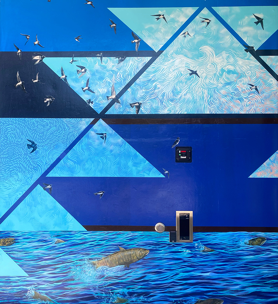 A blue painted mural with geometric pattern and birds flying. There is also a body of water with fish swimming in it.