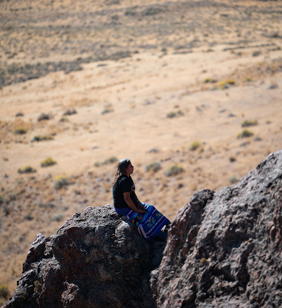 A person sits on a rock among Peehee Mu'huh
