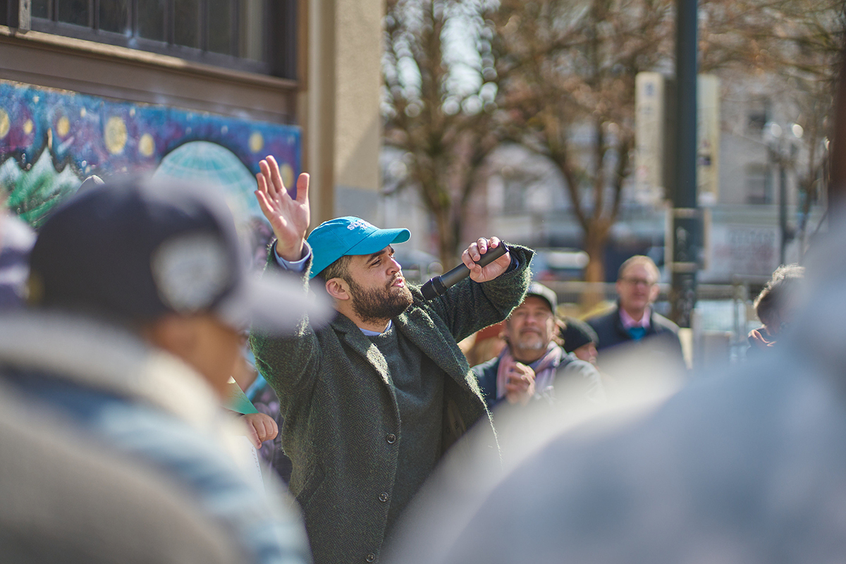 Cody McGraw, Street Roots capital campaign director, led the crowd in waving their hands in the air.