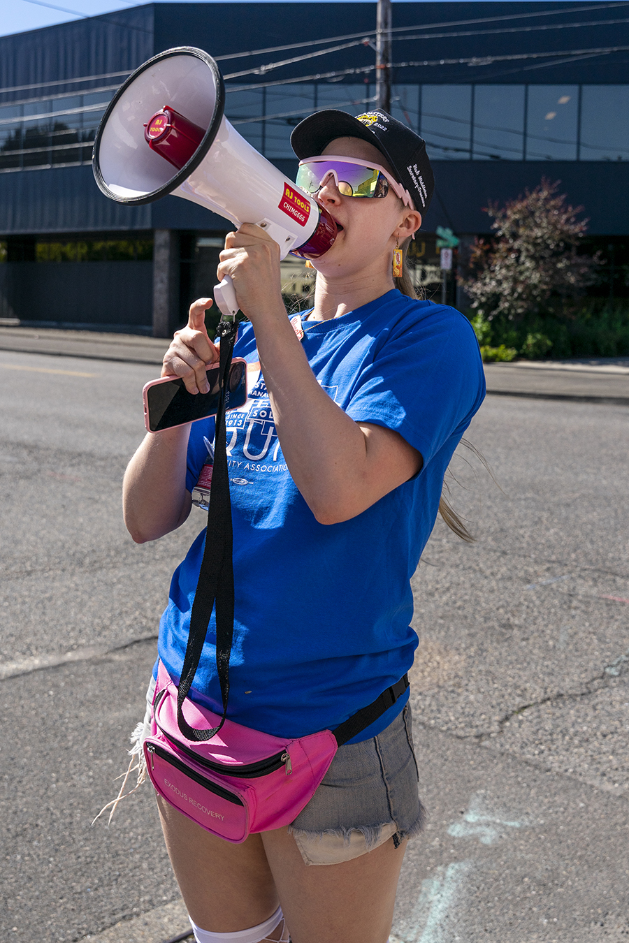 A person holds a megaphone and speaks into it.