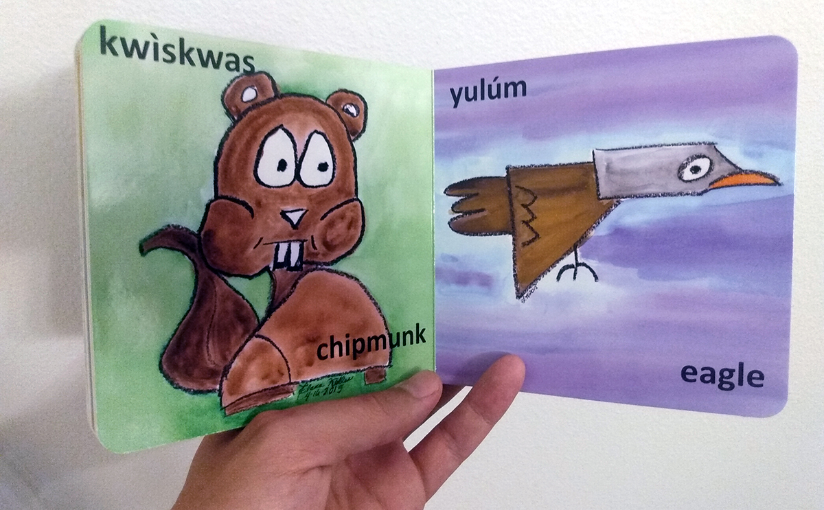 A book depicts a chipmunk and an eagle, each accompanied by both the English word and the Takelma word 