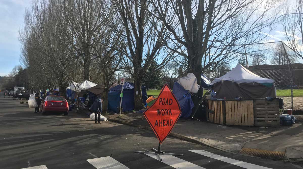 Tents line the sidewalk in front of Sunnyside School Park.