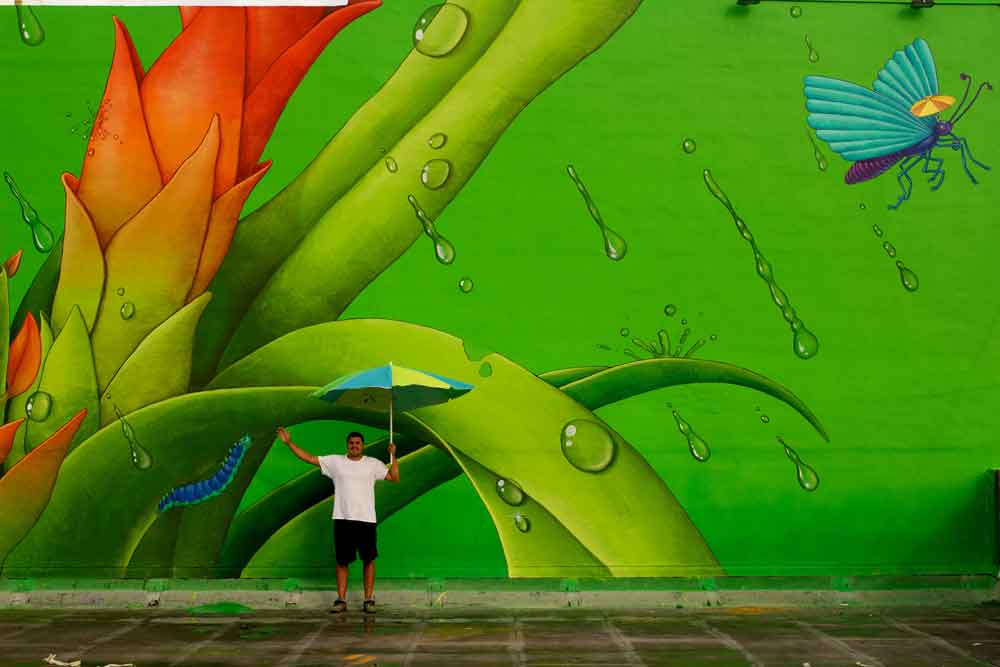 This Miami mural was designed by artists Waone, pictured, and AEC — an art duo known as Interesni Kazki.
