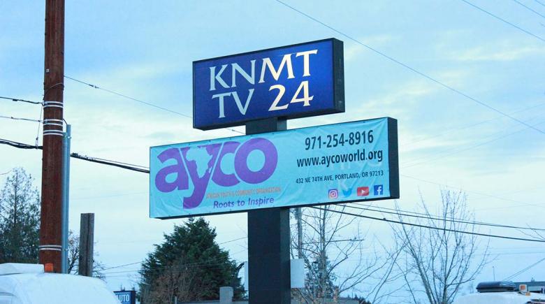 Photo of a two tiered sign that reads "AYCO. African Youth & Community Organization. Roots to inspire."