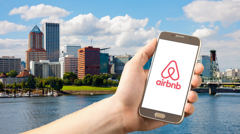 Illustration of phone screen with Airbnb logo, overlooking the Portland skyline