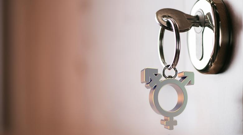 House key with a charm depicting a transgender symbol
