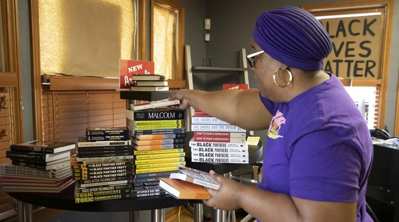Michelle Lewis stacks books at Third Eye Books
