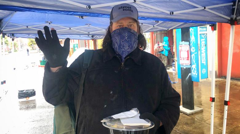 Photo of David Campbell holding a container with biscuits and gravy underneath a tent.