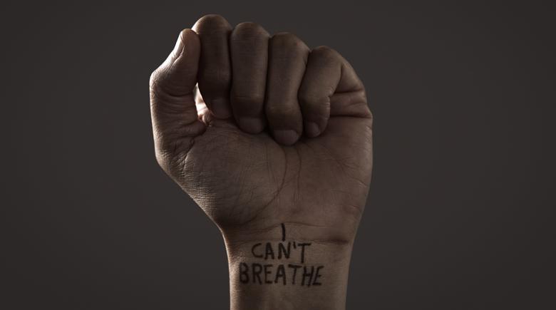 Fist raised. Writing on wrist says: I can't breathe.