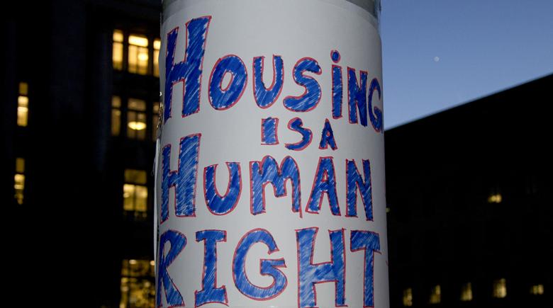 Housing is a Human Right sign on a post