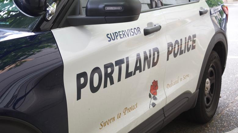 A side view of a Portland Police Bureau vehicle. Text on the side of the car says, "Supervisor. Portland Police. Sworn to protect. Dedicated to serve." with an illustration of a rose.
