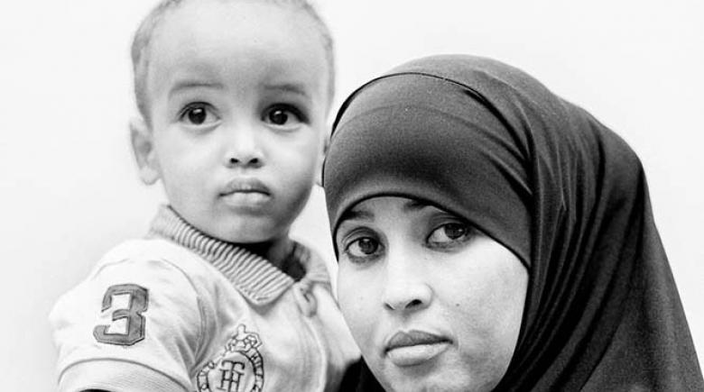 Photo of Hibo Mohamed holding her son in her arms posing for a photo.
