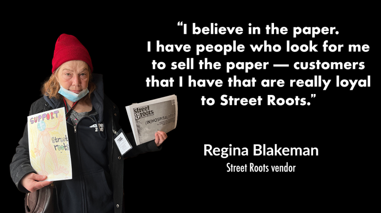 Street Roots vendor Regina Blakeman wears a red beanie and holds up a piece of artwork in one hand and a newspaper in the other.