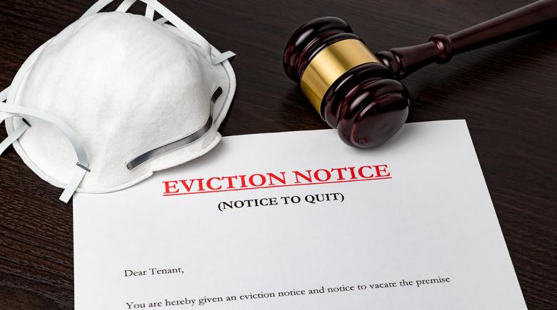 A photo of a piece of paper that reads, "eviction notice" and a mask and gavel rest on top of the paper.