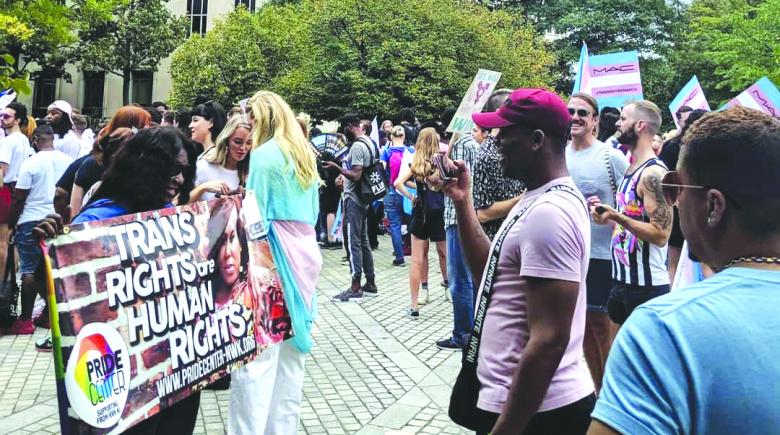 People gather outdoors with signs and banners