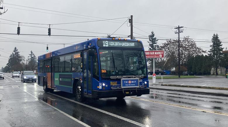 Trimet 19 bus drives down the street on a rainy day.