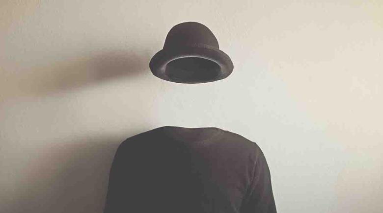 A photo of a body and no head with a floating hat.