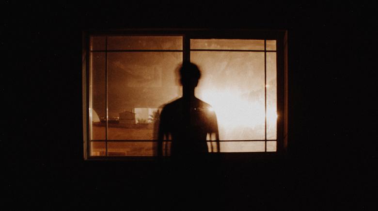 Silhouette of a person in front of a window