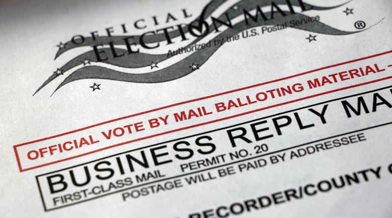 A close up of "vote by mail" envelope.