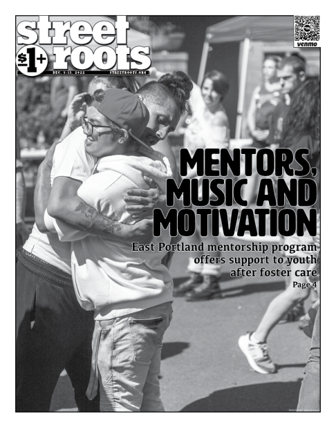 Cover of Street Roots December 7, 2022 issue. A photo of two people hugging is in the background and large, black text in the foreground says, "Mentors, music and motivation. East Portland mentorship program  offers support to youth after foster care."