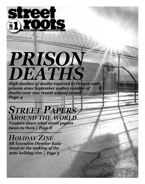 Front cover of Street Roots Dec. 1, 2021 issue. The image shows a gated fence around the Oregon State penitentiary.
