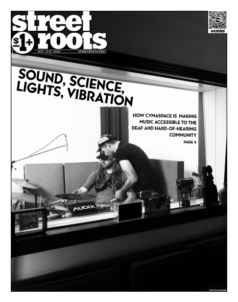 Cover of Street Roots October 11, 2023 issue. In the foreground text says, "Sound, science, text, vibration. HOW CYMASPACE IS  MAKING MUSIC ACCESSIBLE TO THE DEAF AND HARD-OF-HEARING COMMUNITY. PAGE 4." In the background is a photo of two people in a stud